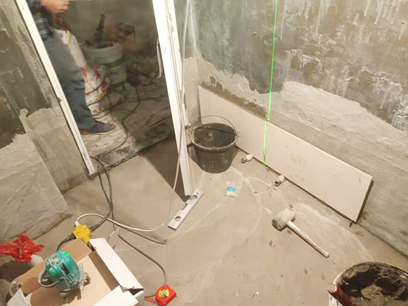 衛(wèi)生間墻面貼磚：施工前將需要的材料整齊堆放在一旁待用。首先應(yīng)除去基層表面的污垢，油漬，浮灰;除去基層上所有涂料層，膩子層;如果基層未能達(dá)到平整度要求，需對基層進(jìn)行預(yù)先的找平處理。 鋪貼瓷磚前需事先找好垂直線，以此為基準(zhǔn)鋪貼的瓷磚高低均勻、垂直美觀;此外，施工前在墻體四周需彈出標(biāo)高控制線，在地面彈出十字線，以控制地磚分隔尺寸。 加水后將粘結(jié)劑漿料攪拌至潤滑均勻，無明顯塊狀或糊狀結(jié)塊，攪拌后的漿料靜置5-10分鐘后再稍加攪拌1-2分鐘即可使用。在開始鋪貼施工前，需要先清理瓷磚表面的浮灰，污垢等。將調(diào)制好的漿料均勻地抹在瓷磚背面，要求漿料飽滿。將瓷磚平整地鋪貼在基層上，使用橡膠錘將瓷磚拍實鋪平。施工過程中，可小幅度轉(zhuǎn)動瓷磚，使?jié){料與瓷磚背面充分接觸。